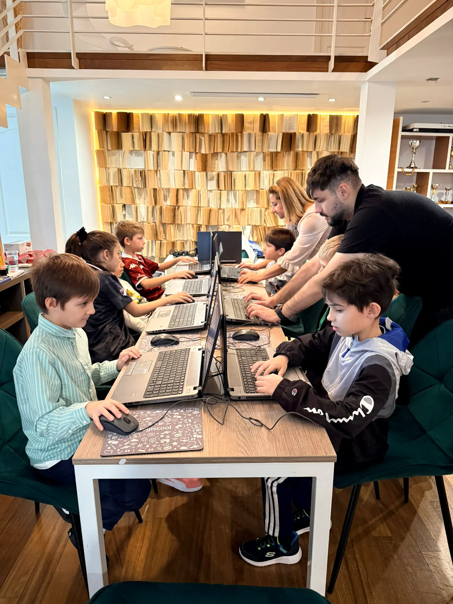 Laboratorul online: copii analizând partide pe laptopuri
